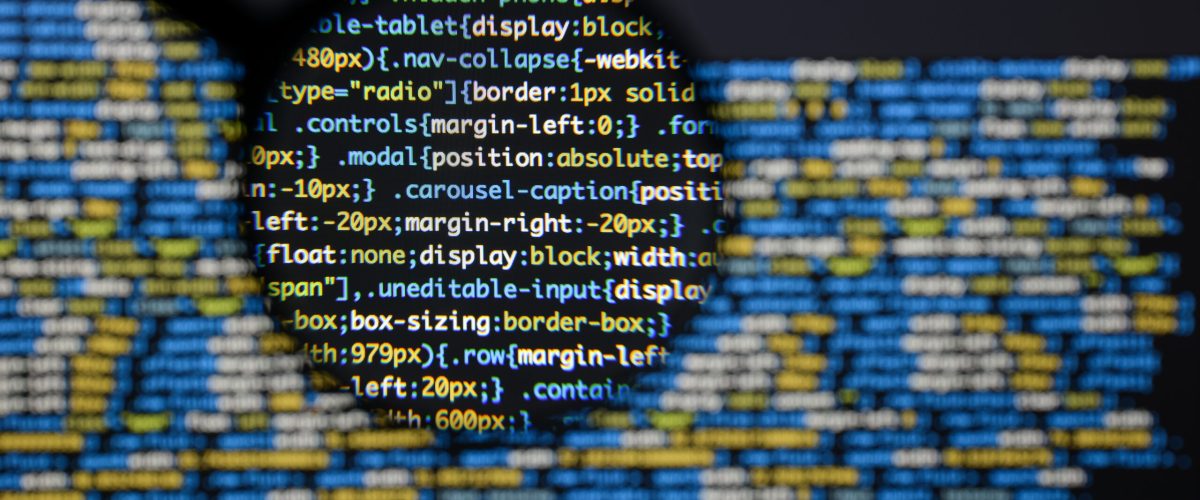 Real css code developing screen. Programing workflow abstract algorithm concept. Lines of css code visible under magnifying lens.